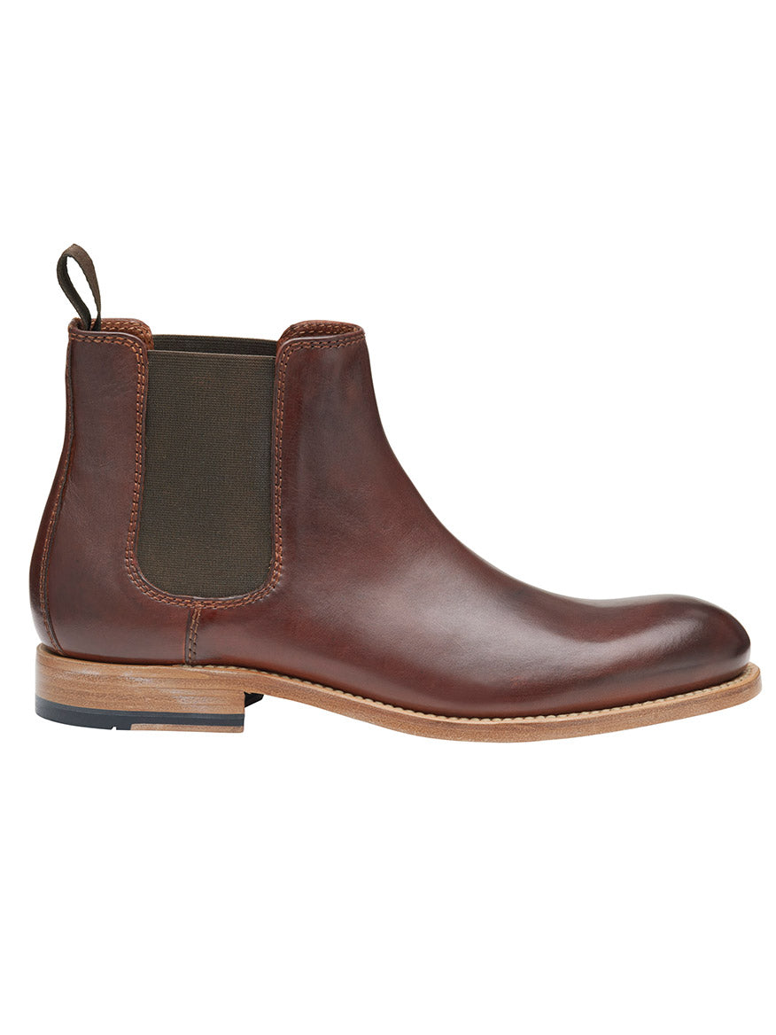 The J & M Collection Dudley Chelsea Boot in mahogany dip-dyed calfskin features elastic side panels and a pull tab at the back. This boot has a wooden heel, a Goodyear welt, and a leather sole with a rubber grip.