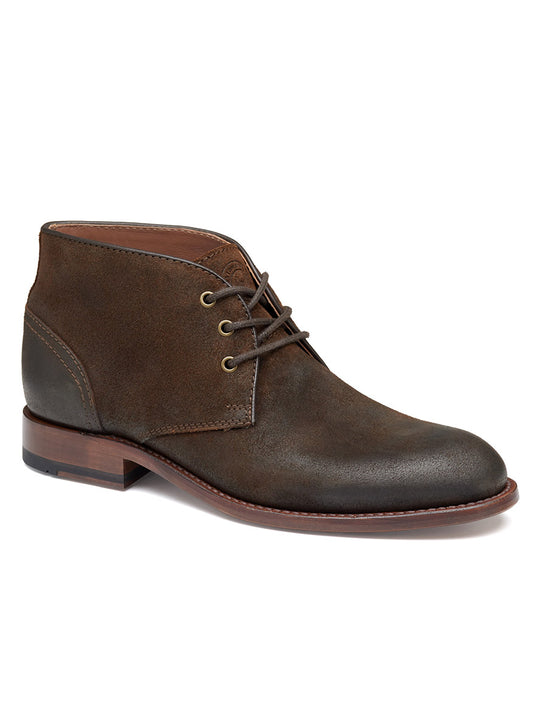 The J & M Collection Dudley Chukka in Brown Waxed English Suede is a single dark brown suede ankle boot with three eyelets for laces, a rounded toe, and a brown wooden heel, featuring Goodyear welt construction for added durability.