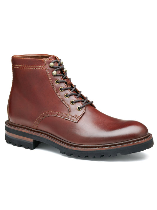 The J & M Collection Dudley Lug Plain Toe Boot in Mahogany Full Grain is a single brown leather lace-up boot with metal eyelets, crafted from vegetable-tanned leather. It features a thick black rubber sole for ultimate durability and is enhanced by Goodyear welt construction, ensuring long-lasting wear and exceptional comfort.