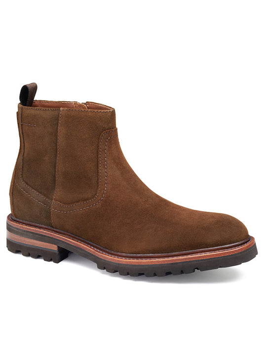 The J & M Collection Dudley Zip Boot in Brown Waxed English Suede is an ankle boot featuring a pull-tab at the back, a side zipper, and a thick, rugged sole with Goodyear welt construction for added durability.