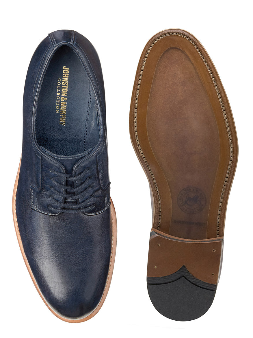 Top view of a J & M Collection Dudley Plain Toe in Navy Dip-Dyed Calfskin next to its sole, showing the brand label and tread design.