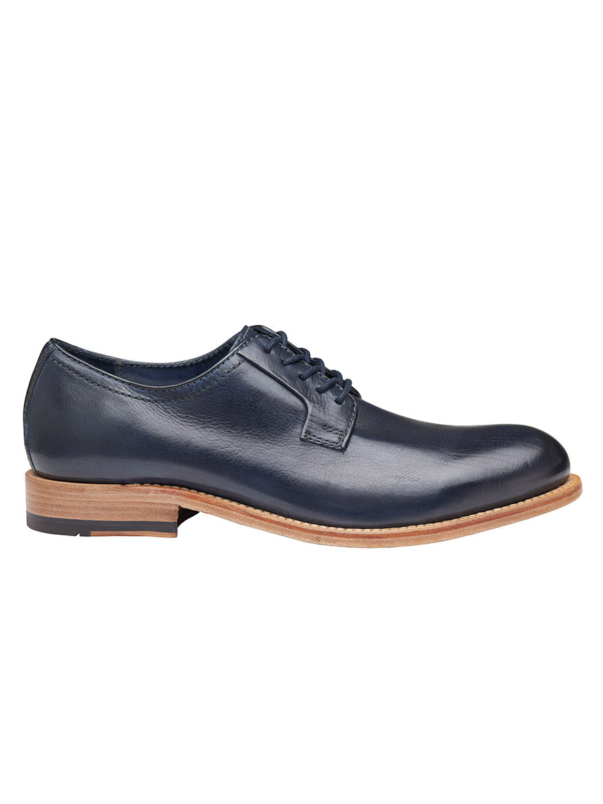 A single J & M Collection Dudley Plain Toe in Navy Dip-Dyed Calfskin with laces on a plain background, featuring a low heel and tan sole.
