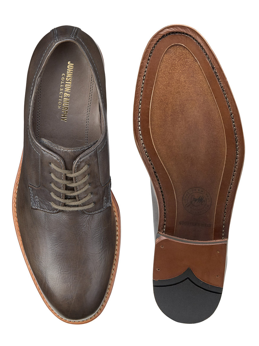 A brown leather J & M Collection Dudley Plain Toe in Dark Grey Dip-Dyed Calfskin dress shoe viewed from above next to its sole showing craftsmanship details, including the Goodyear welt technique.