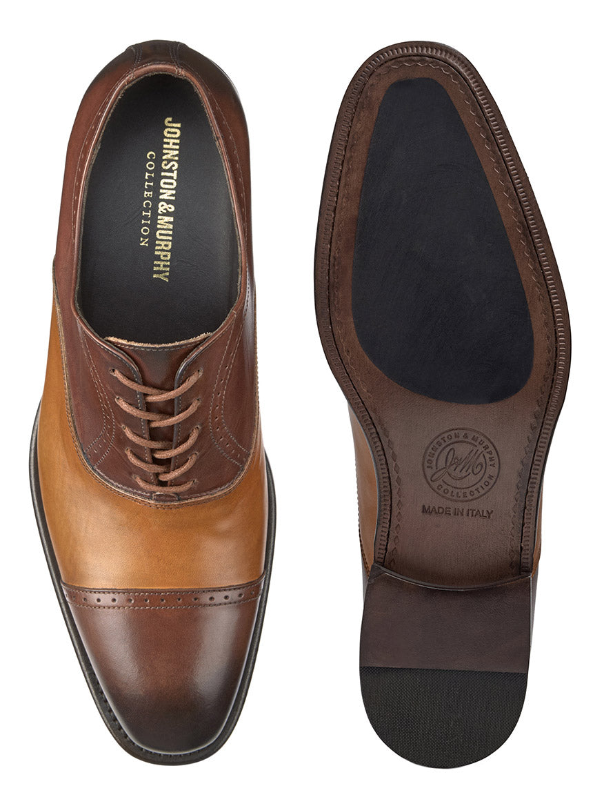 The J & M Collection Ellsworth Cap Toe Balmoral shoes in Brown/Tan Italian Calfskin feature a laced left shoe with "Johnston & Murphy Collection" branding. The sole is marked "Made in Italy," and it includes a leather lining for comfort, shown from top and sole views.