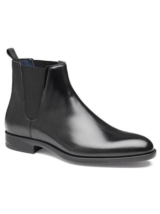 The "J & M Collection Flynch Chelsea Boot in Black Italian Calfskin" features an elegant black leather design with an Italian calfskin upper, elastic side panels, a pull tab at the back, and a low heel.