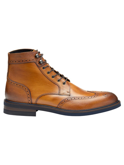 The J & M Collection Hartley Wingtip Boot in Tan Hand-Stained Calfskin features intricate perforated detailing, black laces, and a dark-colored Vibram EVA outsole.