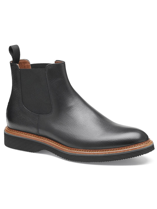 The J & M Collection Jenson Chelsea Boot in Black Tumbled Calfskin features a black leather design with a brown welt, black elastic side panels, a pull tab at the back, a leather-covered footbed, and a high-abrasion EVA outsole.