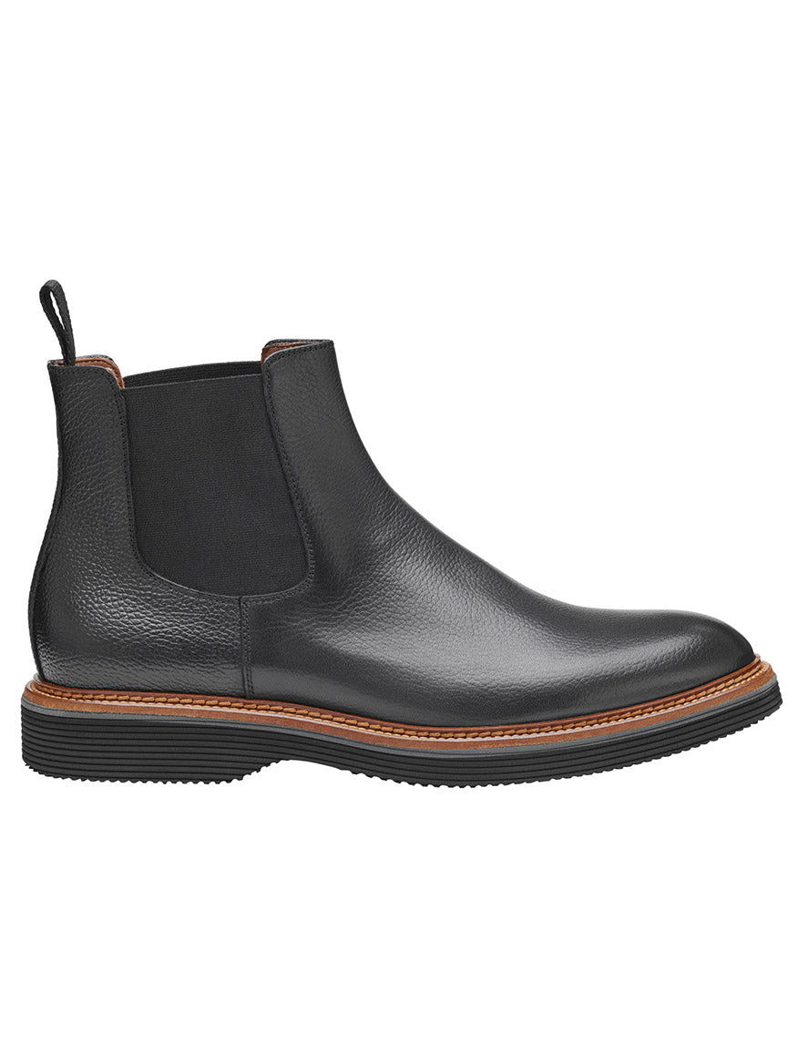 The J & M Collection Jenson Chelsea Boot in Black Tumbled Calfskin showcases a comfortable leather-covered footbed, black elastic side panels, and a brown sole, all set against a white background.