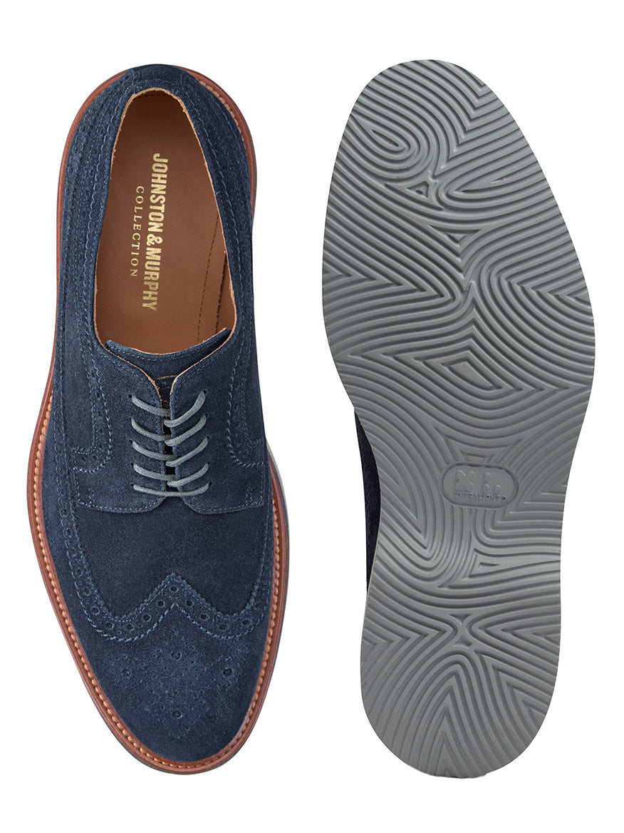 A pair of J & M Collection Jenson Longwing in Navy Suede, featuring a brown welt and a gray wavy-patterned XL EXTRALIGHT® rubber outsole. The insole is branded with "Johnston & Murphy Collection.