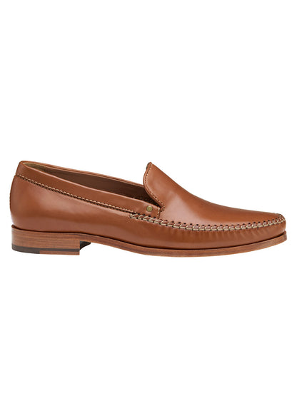 The J & M Collection Baldwin Venetian in Cognac Sheepskin is a brown leather loafer with moccasin construction, visible side stitching, and a flat sole, viewed from the side.