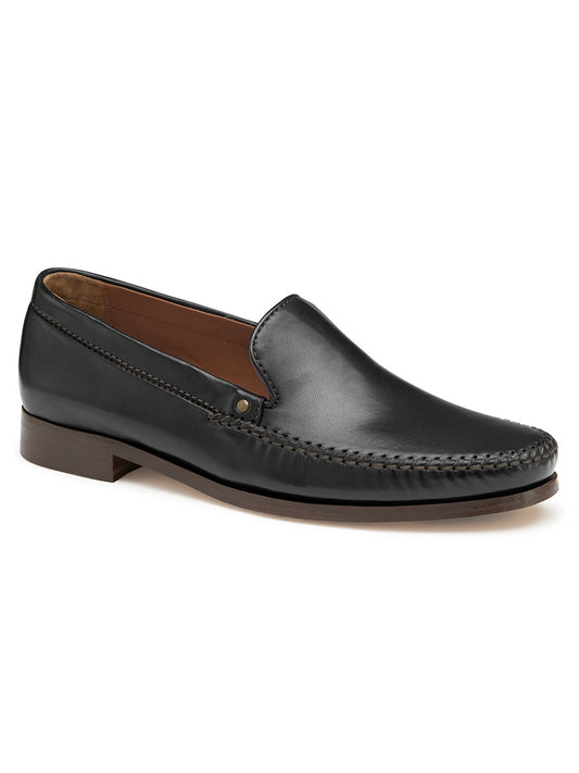 The J & M Collection Baldwin Venetian in Black Sheepskin is a slip-on moccasin with a brown sole, front stitching detail, and a cushioned footbed for extra comfort.