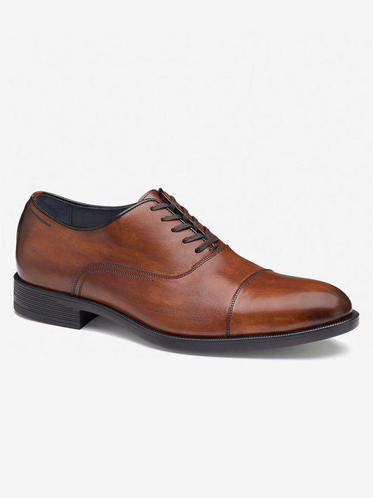 The J & M Collection Flynch Cap Toe in Tan Italian Calfskin is a brown leather dress shoe with a cap toe, black laces, and a low heel on a white background.