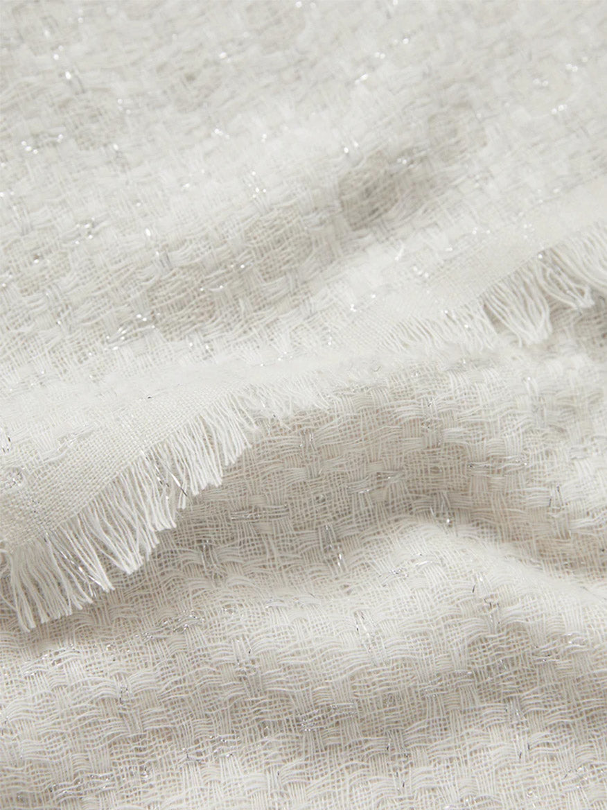 Close-up of a Jane Carr The Tile Scarf in White with fringed edges.