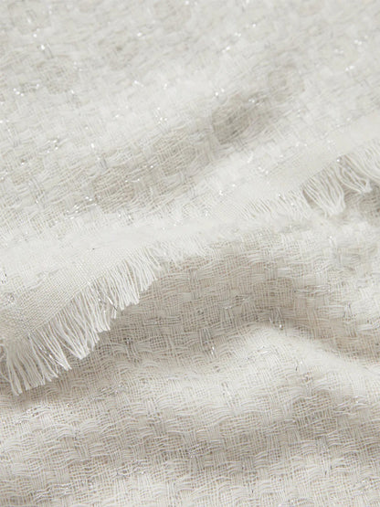 Close-up of a Jane Carr The Tile Scarf in White with fringed edges.