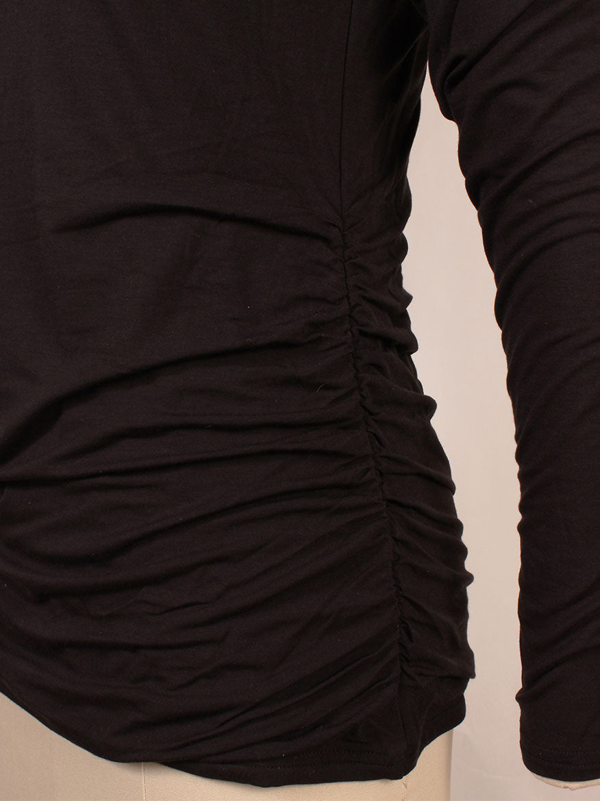 Side view of a person wearing the Kinross Ruched Long Sleeve Vee in Black, featuring ruched details on the side and a flattering vee neckline.