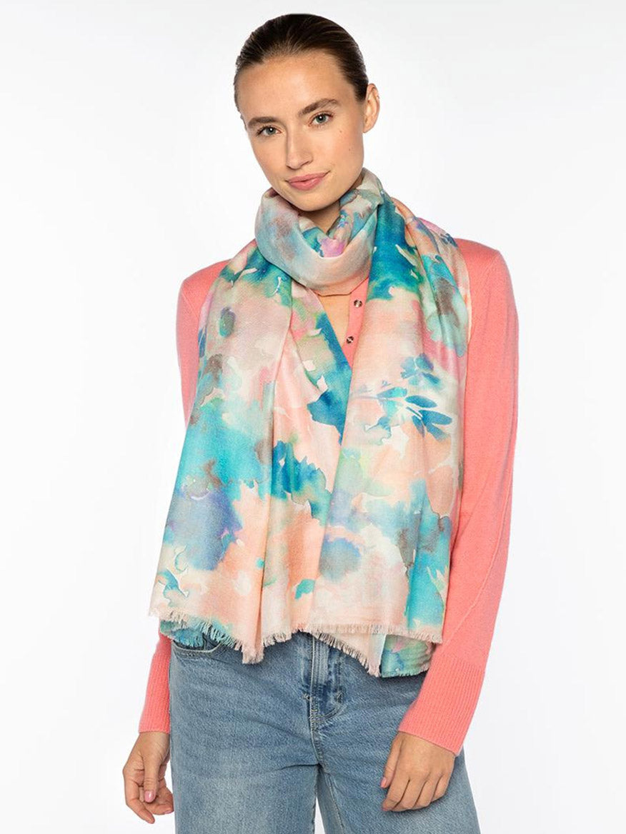 A woman wearing the Kinross Maldives Floral Print Scarf in Multi, elegantly draped—crafted from a luxurious wool, silk, and cashmere blend.