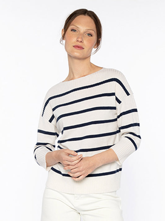 A woman wearing a Kinross Rib Yoke Stripe Pullover in Ivory/Navy and white pants.