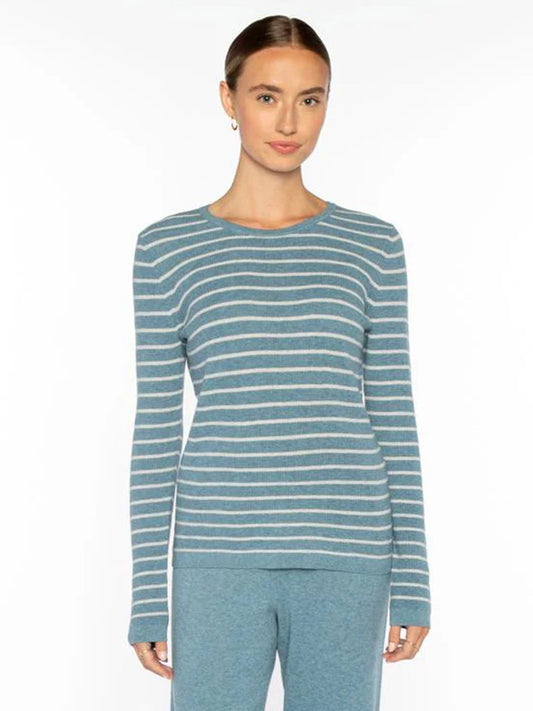 A woman wears the Kinross Texture Stripe Crew in Denim/Greystone, a cozy blue and white knit sweater with textured stripes, paired with matching blue pants, standing against a plain white background.