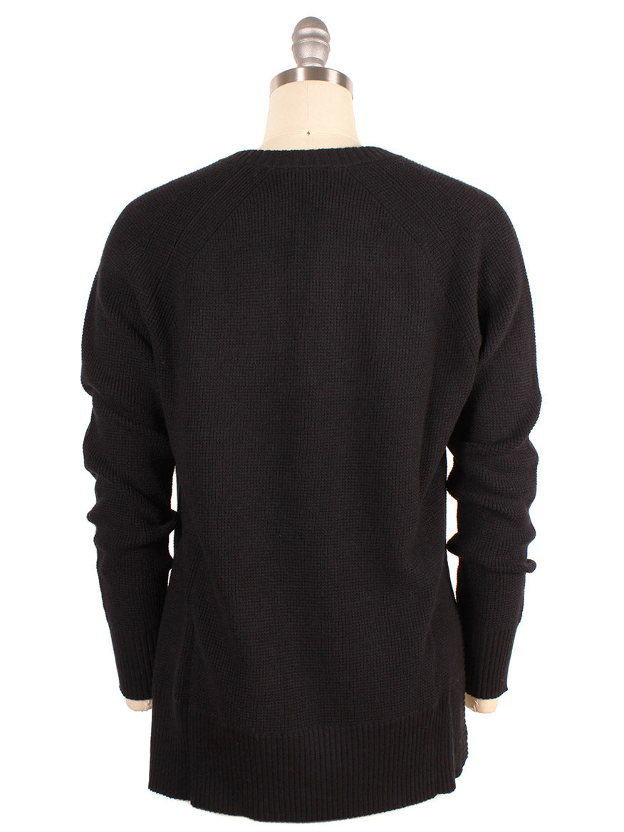 The image displays the back view of a Kinross Thermal Hi Low Henley in Black on a dress form mannequin. This long-sleeved thermal sweater features a ribbed texture and a round neckline.