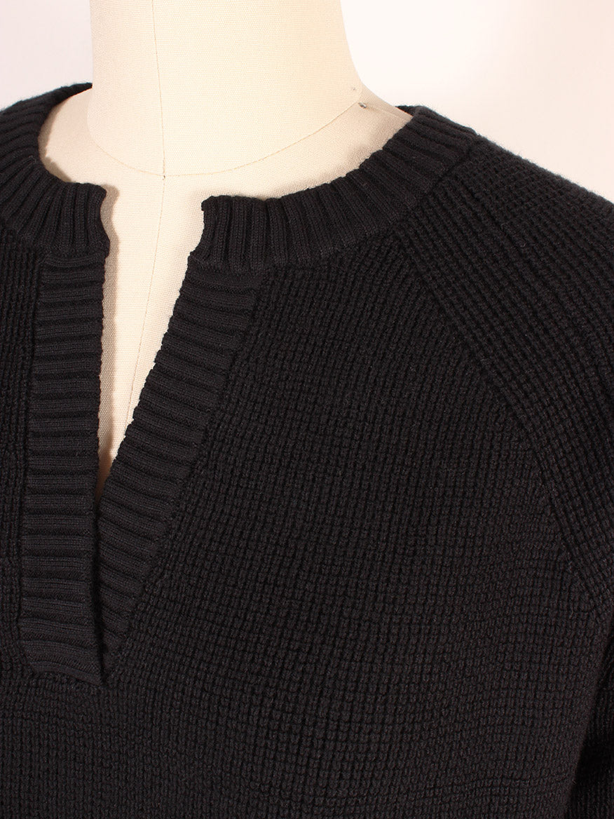 Close-up of the Kinross Thermal Hi Low Henley in Black, displayed on a mannequin. This Cotton/Cashmere blend sweater features a notched neckline, raglan sleeves, and offers the cozy comfort reminiscent of a long sleeve thermal.