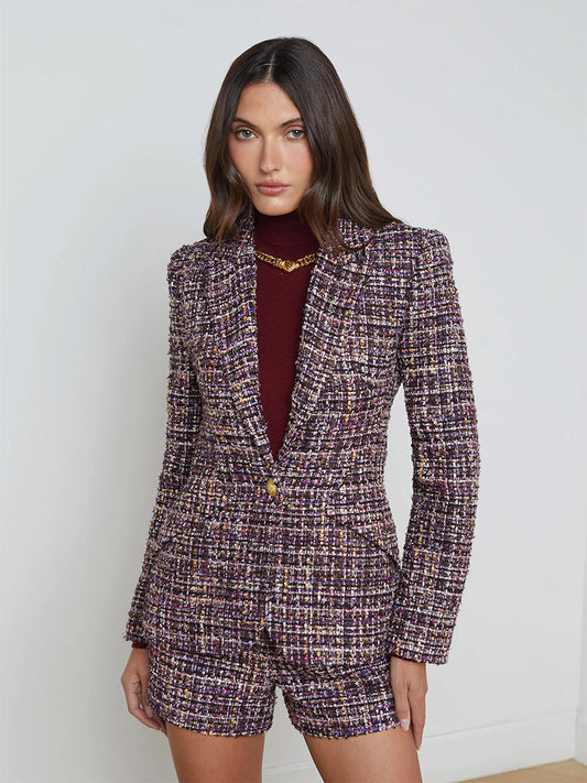 A person wears the L'Agence Chamberlain Tweed Blazer in Purple Multi along with matching plaid shorts and a maroon top underneath, standing in a neutral setting.