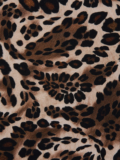 Close-up of the L'Agence Ressi Fitted Tee in Cinnamon Swirl Paisley Leopard, showcasing black and dark brown spots on a light tan background—ideal for a chic short sleeve look.