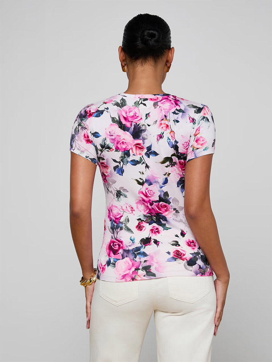 A woman, shown from the back, wears the L'Agence Ressi Fitted Tee in Pink Multi Water Rose with light-colored pants.