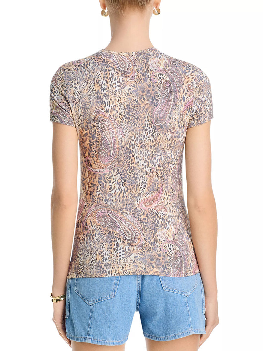 Model wearing the L'Agence Ressi Fitted Tee in Valencia Leopard, a slim-fit bestseller with a leopard paisley print, paired with blue denim shorts, shown from the back against a plain background.