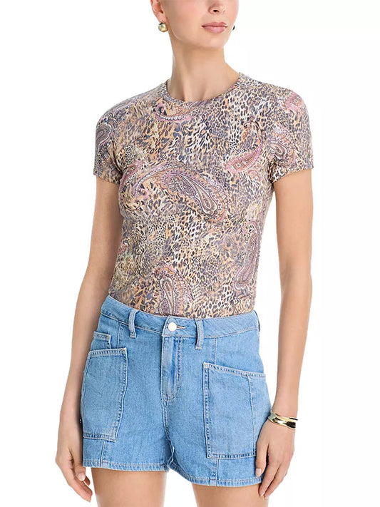 A woman wears the L'Agence Ressi Fitted Tee in Valencia Leopard with high-waisted, light blue denim shorts featuring large front pockets.