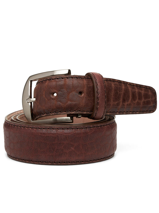 The LEN Belts American Bison Belt, handcrafted in the USA from genuine American Bison leather, showcases a textured pattern and is finished with a silver buckle. It is elegantly coiled on a white background, displaying its rich brown color complemented by brown edge and border stitching.