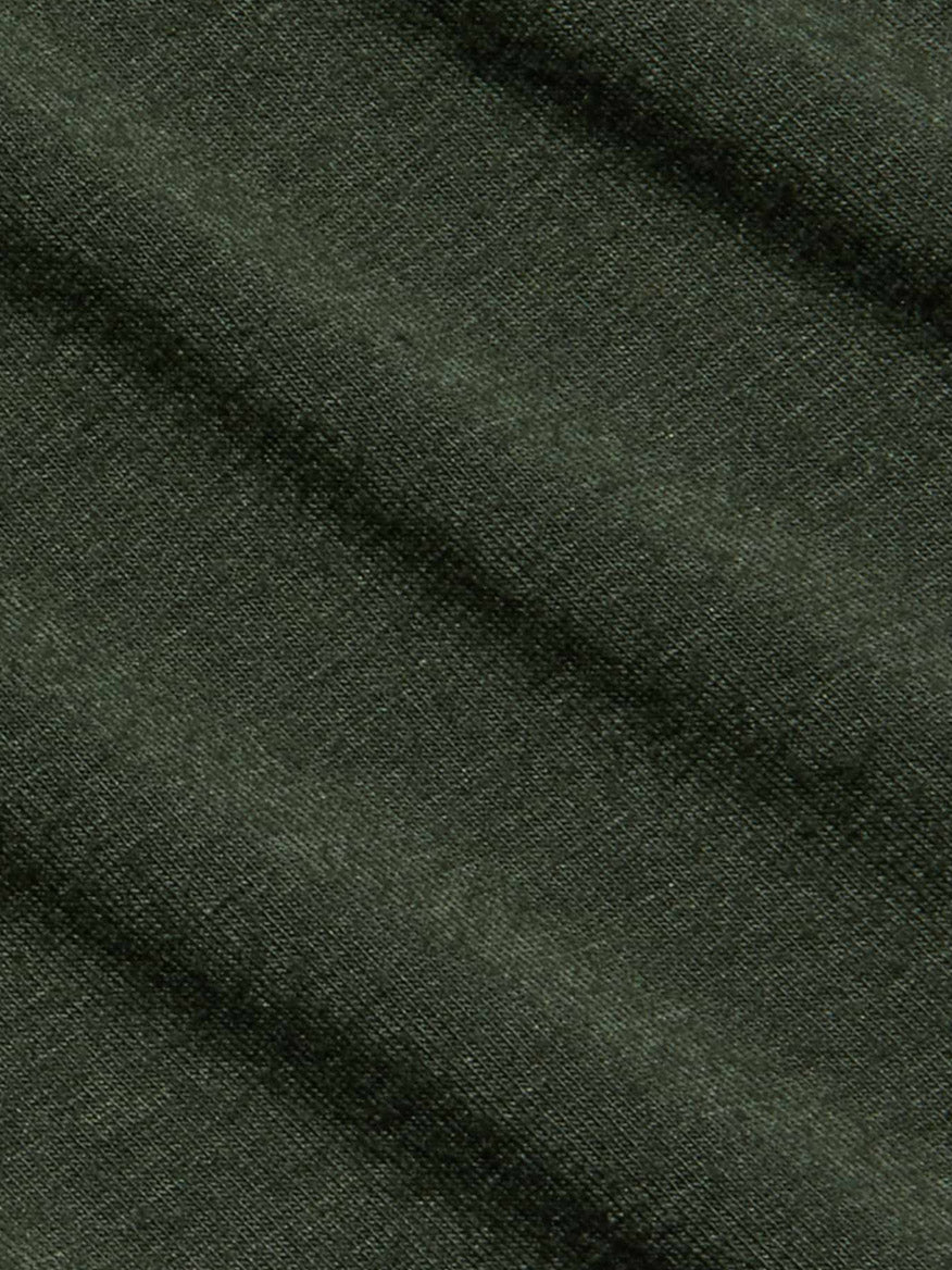 Close-up of dark green textured fabric with visible diagonal folds and a finely woven surface, reminiscent of the ultra-soft knit found in the L’Agence Aja Turtleneck in Army.