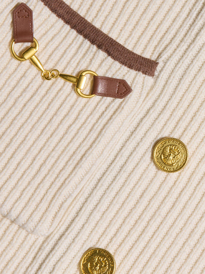 Close-up of the L’Agence Ranch Knit Blazer in Ivory/Dark Cappuccino, featuring an ivory ribbed knit, gold lion head buttons, a gold horsebit detail with brown leather tabs, and brown trim.