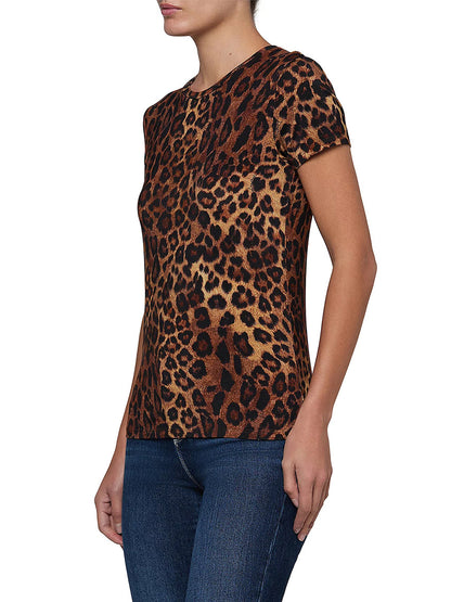 A person wearing the L’Agence Ressi Short Sleeve Crew in Tan Multi Javan Leopard and blue jeans, standing against a white background.