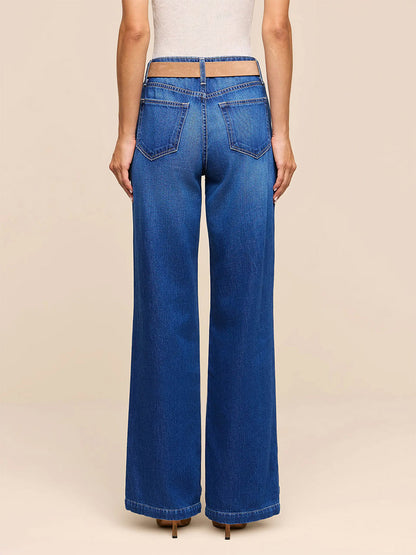 A person is seen from the back against a plain background, wearing the L’Agence Scottie Wide-Leg Jean in Idaho—high-waisted, wide-leg blue jeans made from nonstretch denim and featuring a distinctive cutout waistband.