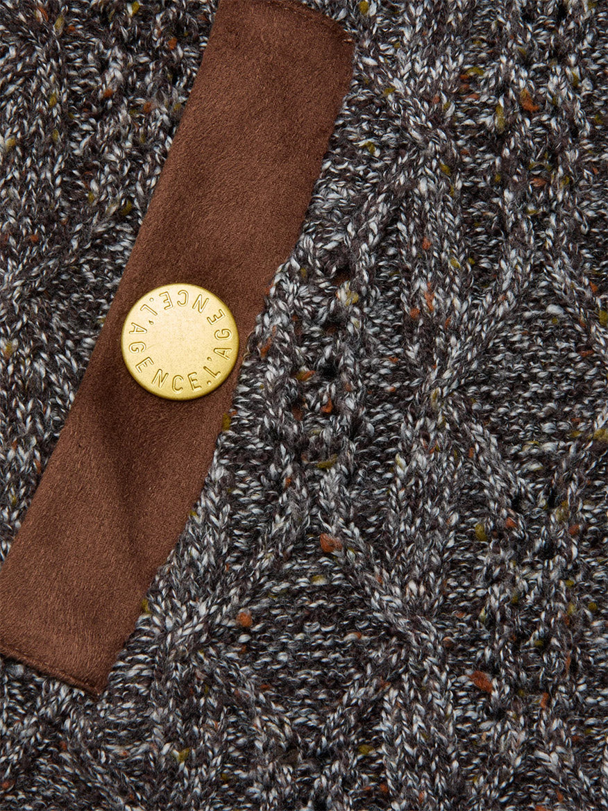 Close-up of the L'Agence Shiloh Cable Knit Cardigan in Carafe Brown Multi, featuring textured gray cable knit with brown accents, a vegan suede strip, and a round gold engraved button.