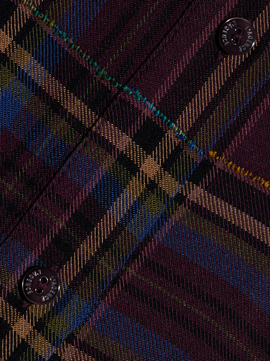 Close-up of the L’Agence Suzette Shirt in Dark Plum Multi Plaid, featuring diagonal multicolored plaid with visible blue and yellow lines, two black buttons, and contrasting stitching along the seam.