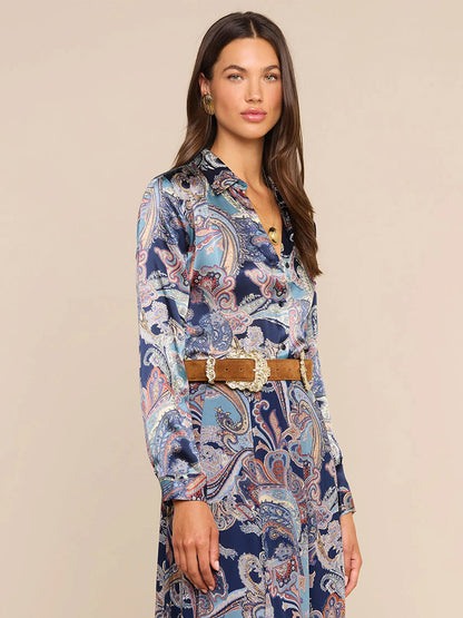 Woman wearing the L’Agence Tyler Blouse in Midnight Multi Besarabian Paisley, styled with a tan belt and standing against a plain background while looking toward the camera—an effortlessly chic look evocative of L’AGENCE style.