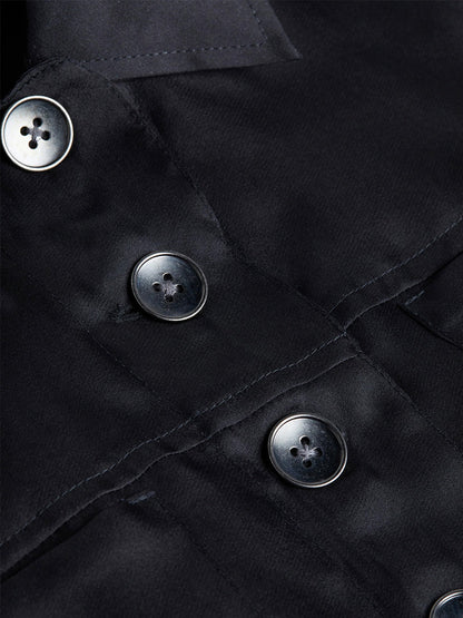 Close-up of the L'Agence Anders Silk Organza Jacket in Black, featuring a cropped fit that highlights its smooth black fabric and four dark buttons sewn in a straight line. The visible stitching around the buttons and seams emphasizes the fine craftsmanship, resembling silk organza in texture.