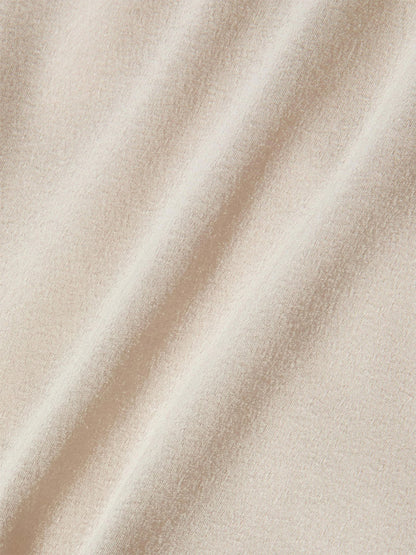 Close-up of the L'Agence Bernice Satin Wrap Blouse in Champagne, featuring soft, textured satin with gentle diagonal folds—ideal for a romantic and elegant look.