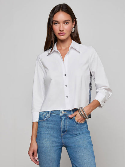 A woman wearing the L'Agence Fawn Panther Print Shirt in Ivory Multi Floral Panther Scarf and blue jeans stands against a plain light gray background.