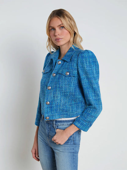 A blonde woman named Kasey wearing a L'Agence Kasey Tweed Jacket in Caribbean Blue Multi Tweed and jeans, standing against a plain white background.