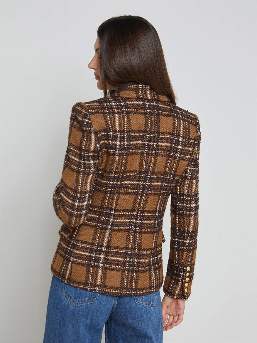 A person is turned away, wearing blue jeans and the L'Agence Kenzie Blazer in blue, brown, and yellow plaid.