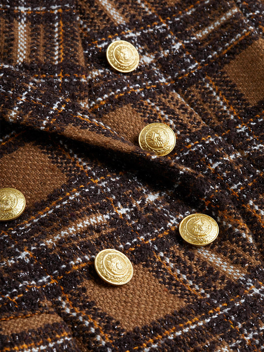 Close-up of the L'Agence Kenzie Blazer in Blue Brown/Yellow Plaid fabric, featuring gold buttons arranged in two rows, highlighting its tailored slim fit.