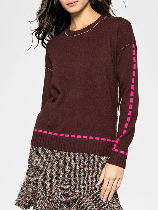 A woman wearing the Lisa Todd Dash Cam Sweater in Coco and a patterned skirt, posing against a plain background.