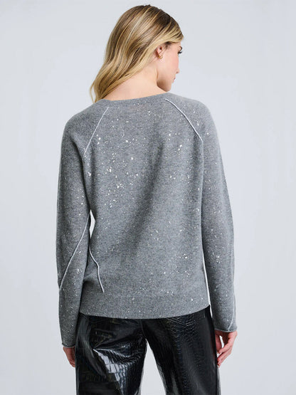 A person with long blonde hair is shown from the back, wearing the Lisa Todd Diamond Dust Sweater in Fog and black textured pants against a plain light background.