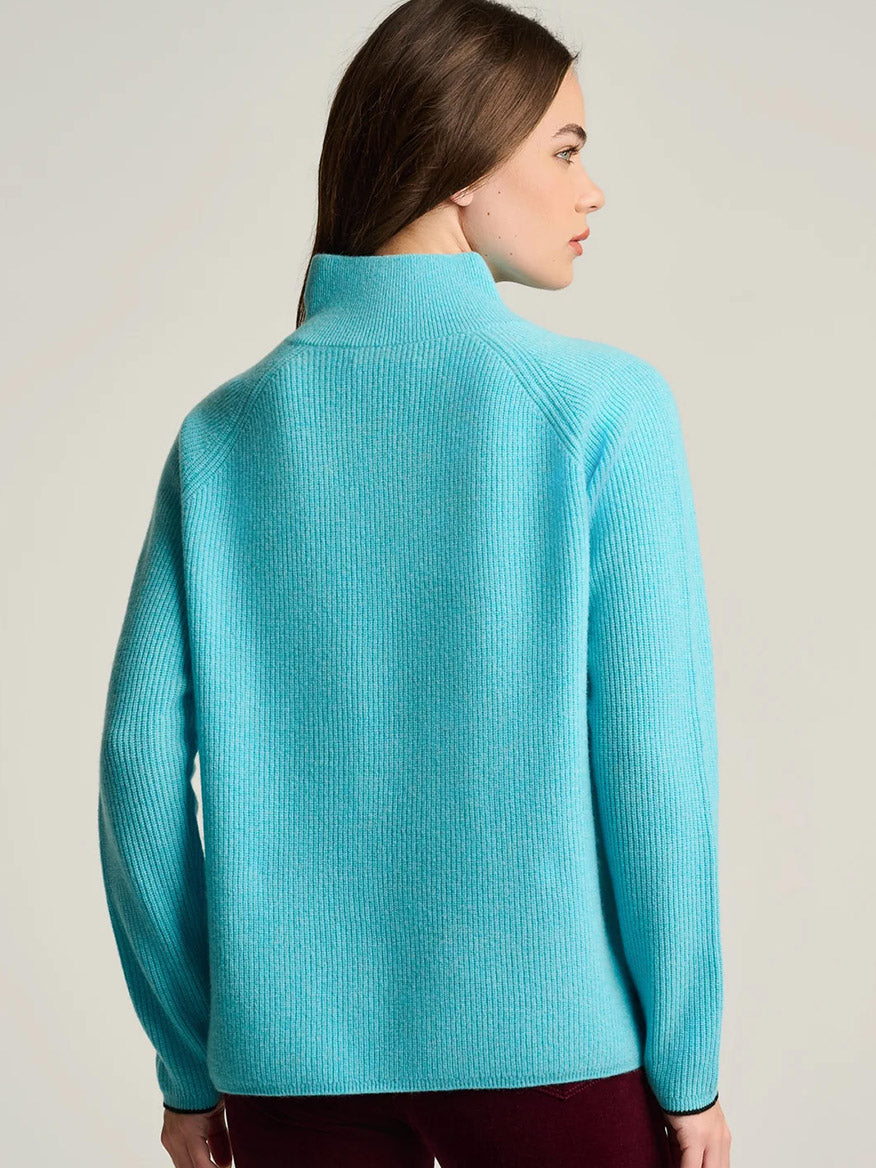 Back view of the bright blue Lisa Todd Double Trouble Cashmere Sweater featuring rib stitching and a mock neck with a contrast zip.