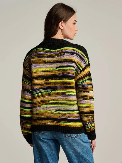 Back view of the Lisa Todd Fillati Sweater in Black Multi, an artisanal long-sleeve knit featuring horizontal stripes in black, yellow, purple, and green.
