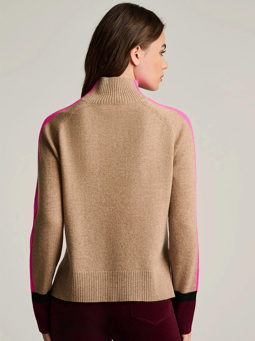 A woman with long brown hair is seen from the back, wearing the Lisa Todd High Spirits Mock in Biscuit and burgundy pants.