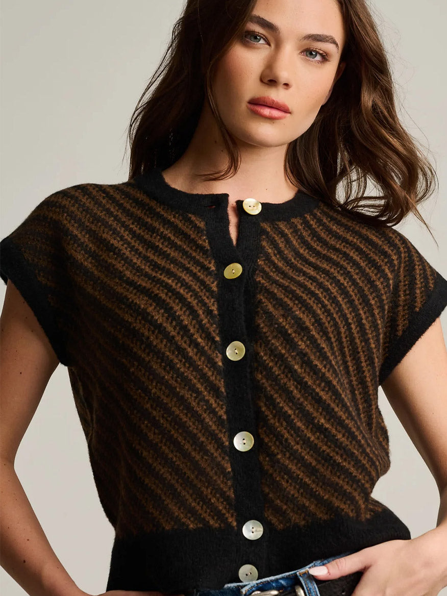 A woman wearing a Lisa Todd In Vest in Black Combo, a black and brown striped sleeveless button-down sweater vest perfect for modern layering.