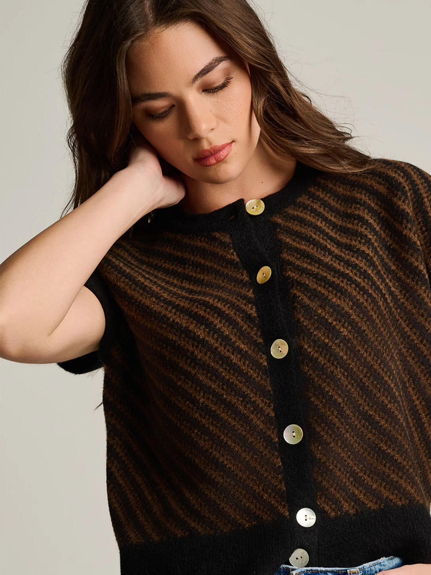 A person wearing a Lisa Todd In Vest in Black Combo, a sleeveless, modern button-down vest with a black and brown diagonal striped pattern.